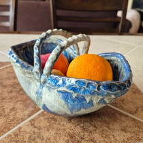 Blue ceramic fruit bowl with handles, handmade pottery flower basket used as kitchen table decor with fresh fruit